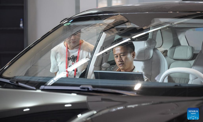 A visitor sits in a new energy vehicle at the 2024 Hainan Autumn Auto Show in Hainan International Conference and Exhibition Center in Haikou, capital of south China's Hainan Province, Sept. 16, 2024. The show was held from Sept. 13 to 16, with nearly one hundred car manufacturers showcasing their products on a display area of more than 50,000 square meters. About 70 percent of the exhibited vehicles were new energy vehicles.  (Photo: Xinhua)