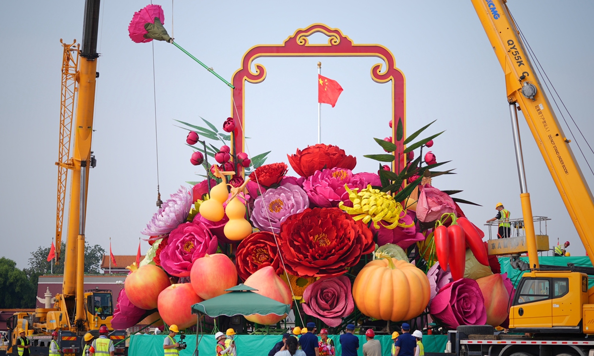 Workers construct the central flowerbed at Tiananmen Square in downtown Beijing on September 18, 2024 for the 75th anniversary celebration of the founding of the People's Republic of China. This year's giant flower basket includes new elements such as vegetables and fruit, highlighting the fragrance of produce and the beauty of blooming flowers. Construction of the basket is scheduled to be completed on September 26, when the basket is unveiled to the public. Photo: VCG