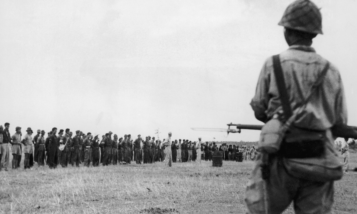 Japanese troops guard American and Filipino prisoners in Bataan in the Philippines after their capture of the Bataan Peninsula in April 1942. Photo: VCG 