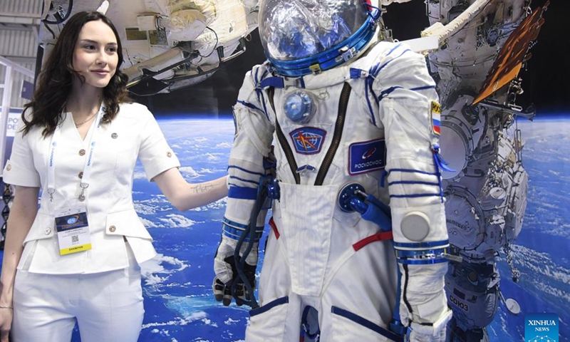 An exhibitor stands next to a space suit at the Bengaluru Space Expo (BSX) 2024 in Bengaluru, India, Sept. 18, 2024. The expo showcased technologies and services related to rocket launching, satellite manufacturing, remote sensing, ground station services, space-based solar power, etc. (Photo: Xinhua)