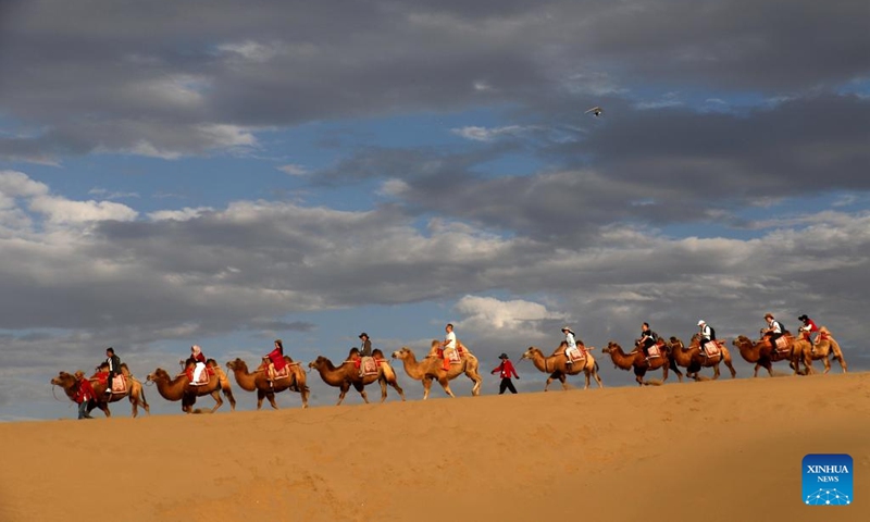 Tourists ride camels at the Mingshashan and Crescent Lake, an oasis scenic spot in the Gobi Desert, in Dunhuang, northwest China's Gansu Province, Sept. 16, 2024.   (Photo: Xinhua)