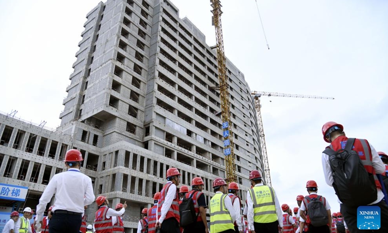 People watch a demonstration of an unmanned remote tower crane working at a construction site in Huangdao District of Qingdao, east China's Shandong Province, Sept. 18, 2024. China Construction Eighth Engineering Division launched its self-developed new generation of unmanned remote tower crane in Qingdao on Wednesday. (Photo: Xinhua)