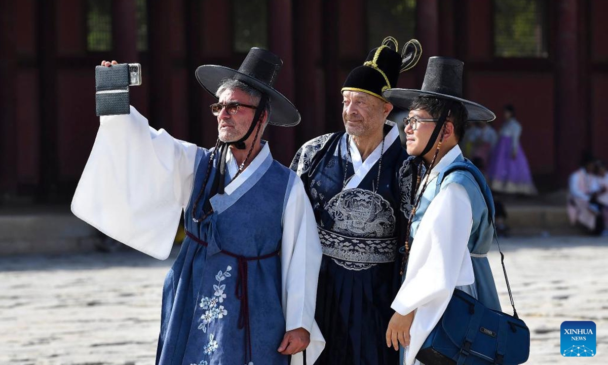 People wearing traditional Hanbok pose for photos as they visit the Gyeongbokgung Palace during the last day of the Chuseok holidays in Seoul, South Korea, Sept. 18, 2024. (Photo: Xinhua)