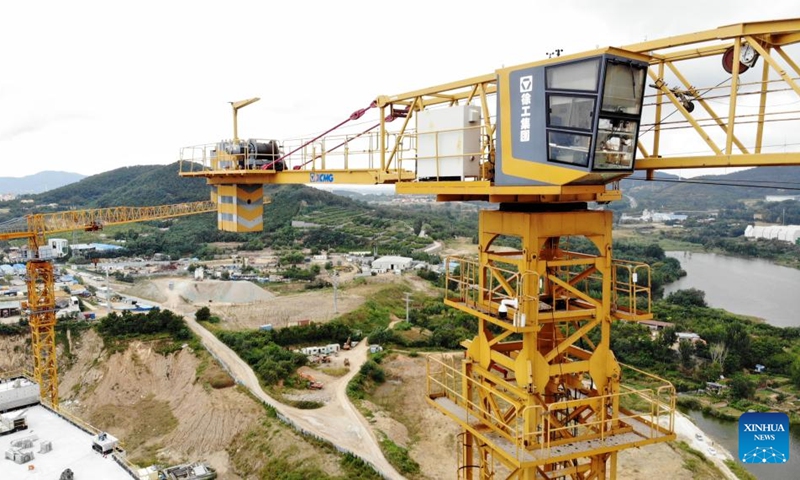 An aerial drone photo shows an unmanned remote tower crane during a demonstration at a construction site in Huangdao District of Qingdao, east China's Shandong Province, Sept. 18, 2024. China Construction Eighth Engineering Division launched its self-developed new generation of unmanned remote tower crane in Qingdao on Wednesday. (Photo: Xinhua)