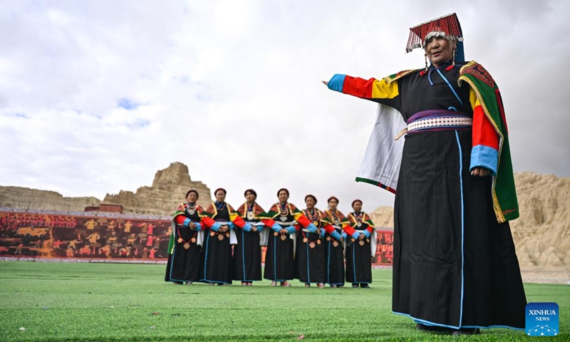 An intangible cultural heritage inheritor (R) of Xuan Dance introduces the dance near the ruins of the Guge Kingdom in Zanda County of Ngari Prefecture, southwest China's Xizang Autonomous Region, Sept. 11, 2024. The dance is a Tibetan cultural heritage from the ancient Guge Kingdom that mixes speech, singing and dancing. It was inscribed into the national intangible cultural heritage list in 2008. (Photo: Xinhua)