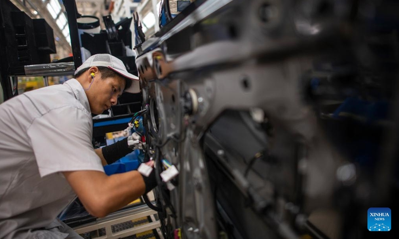 A worker installs the cables to a vehicle at an assembly line of Dongfeng Motor Corporation in Wuhan, central China's Hubei Province, Sept. 6, 2024.   (Photo: Xinhua)