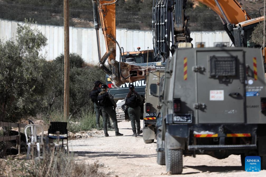 Israeli soldiers stand guard as bulldozers demolish Palestinian residential houses in the village of Beit Awa near the West Bank city of Hebron, on Sept. 19, 2024. (Photo: Xinhua)