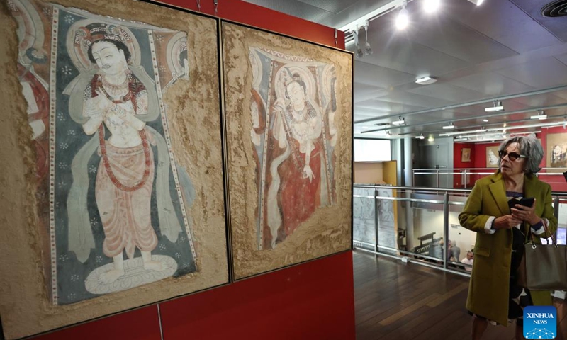 A woman visits the Silk Road Danqing, an exhibition of copies of cave temple mural paintings along the ancient Silk Road at the China Cultural Center in Paris, France, Sept. 18, 2024. The exhibition will last till Sept. 24, 2024. (Photo: Xinhua)