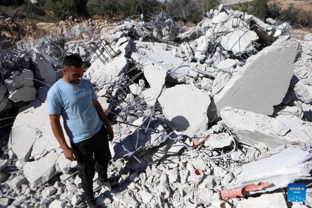 A man stands among the rubble of a house after it was demolished in the village of Beit Awa near the West Bank city of Hebron, on Sept. 19, 2024. (Photo: Xinhua)