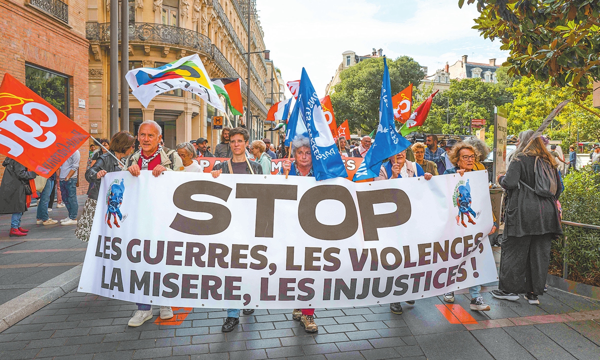 A procession of a pacifist rally marches behind the banner 