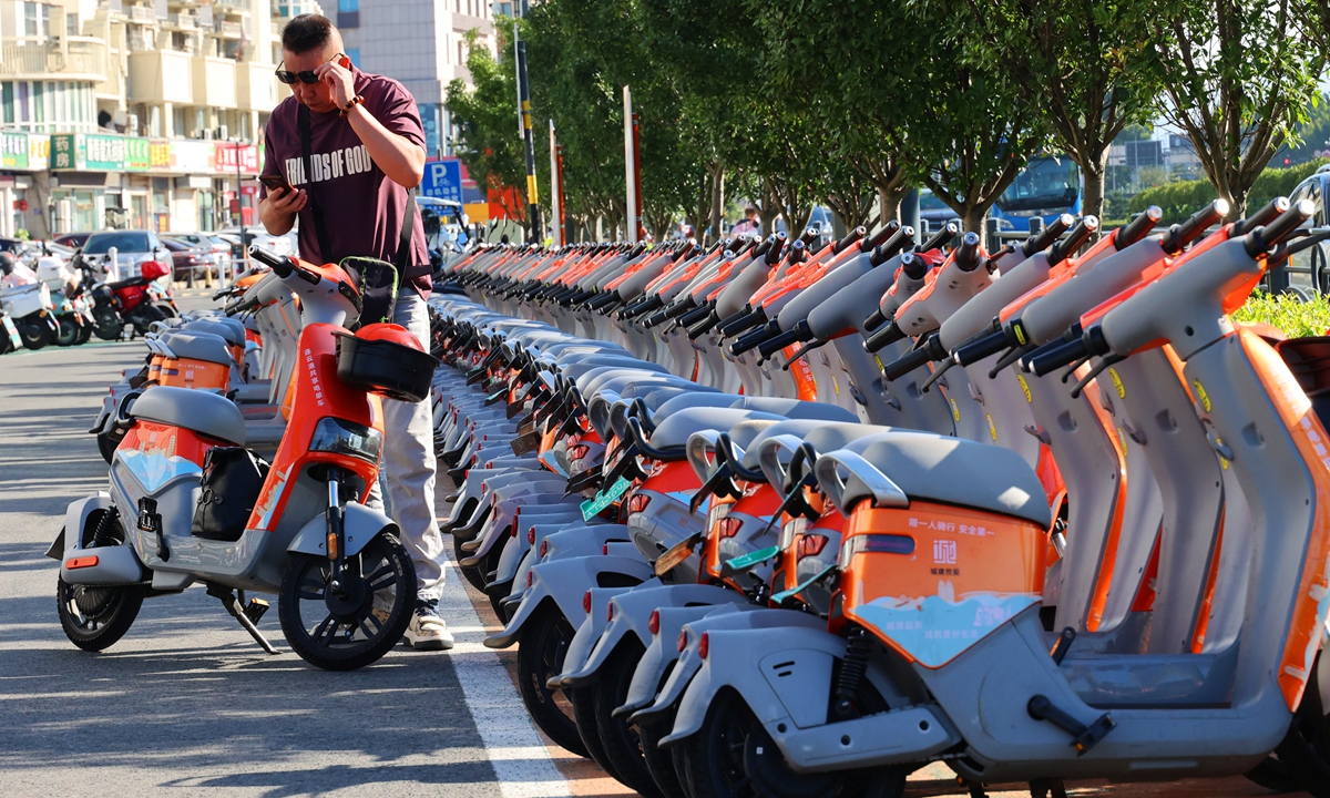 A rider swipes a code for a shared e-scooter in Lianyungang, East China's Jiangsu Province on September 22, 2024. Shared e-bikes are now available in more than 300 Chinese cities, with 15 million in service, according to the Xinhua News Agency. Photo: cnsphoto