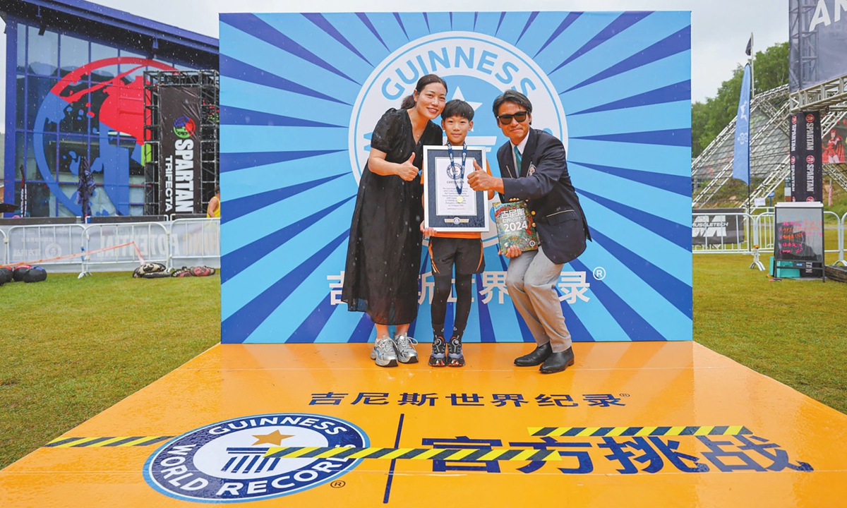 Ben Yuechen (center) poses for a photo with his World Record certificate along with his mom Cai Xiumei (left). Photo: Courtesy of SECA