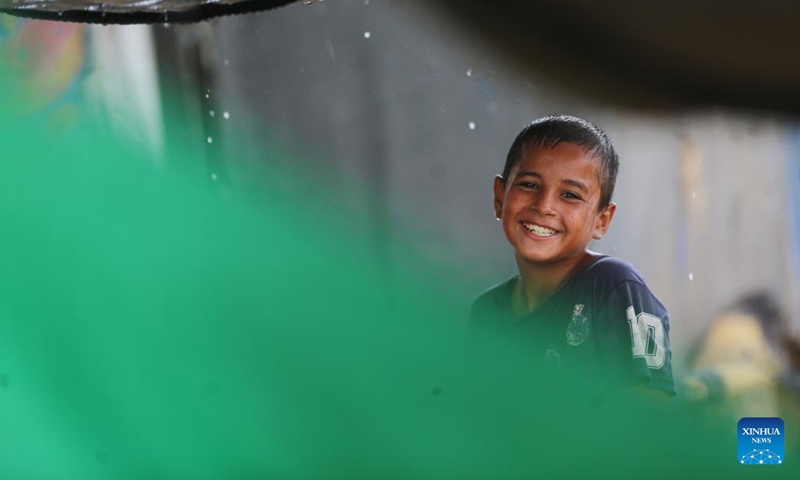 A Palestinian boy plays in the rain in Deir al-Balah in central Gaza Strip, Sept. 22, 2024. (Photo: Xinhua)