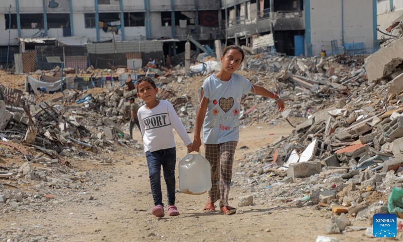 Palestinian children are pictured amid destroyed buildings in the southern Gaza Strip city of Khan Younis, Sept. 22, 2024. (Photo: Xinhua)