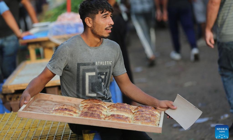 A vendor promotes pastries at a market in Deir al-Balah in central Gaza Strip, Sept. 22, 2024. (Photo: Xinhua)