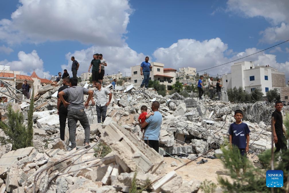 People stand among the rubble of a house after it was demolished by Israeli bulldozers in the village of Idna, west of the West Bank city of Hebron, on Sept. 23, 2024. (Photo: Xinhua)