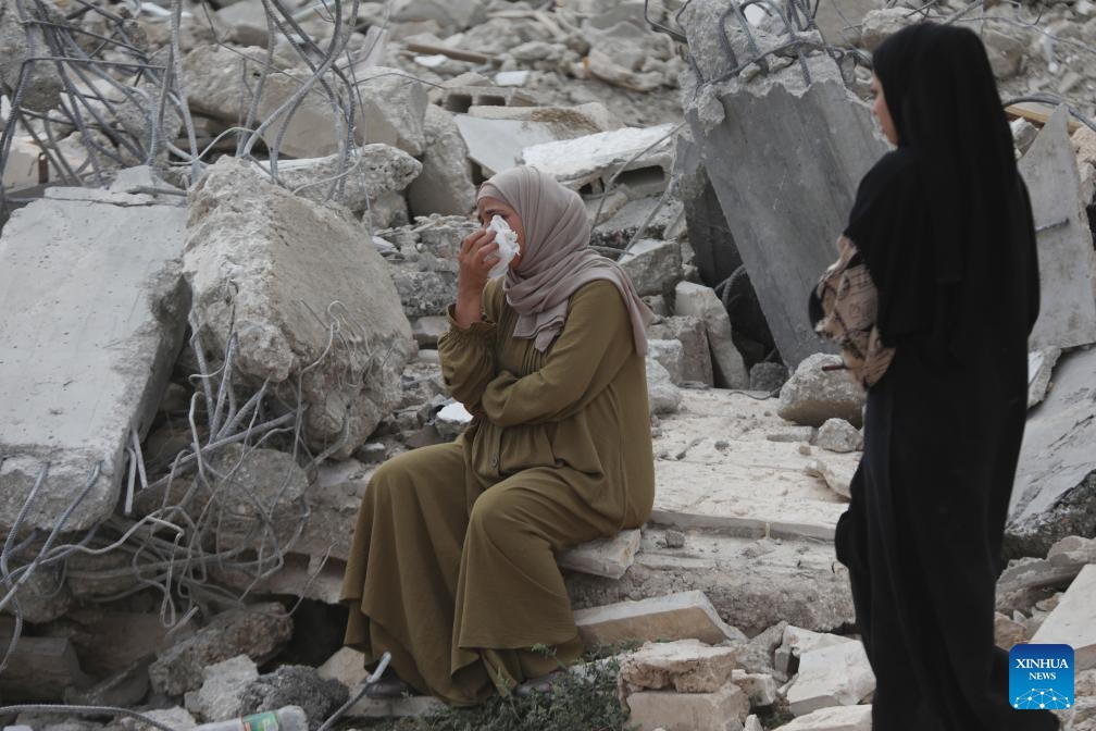 A woman sits among the rubble of a house after it was demolished by Israeli bulldozers in the village of Idna, west of the West Bank city of Hebron, on Sept. 23, 2024. (Photo: Xinhua)