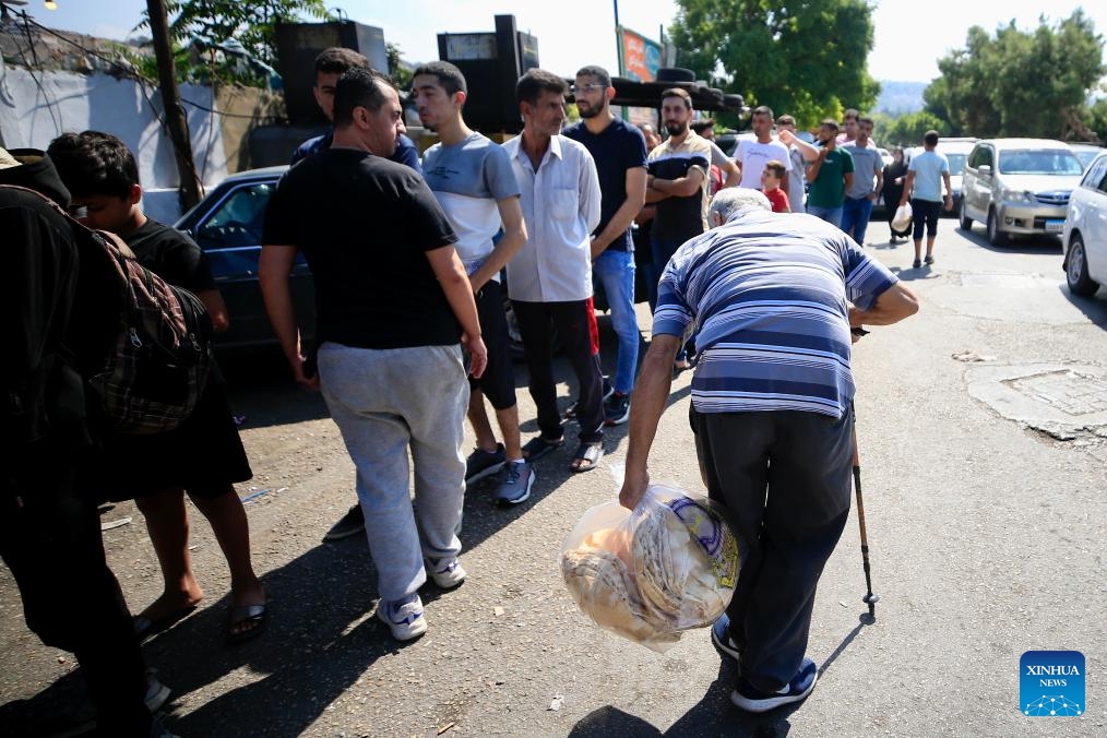 Displaced people line up to buy bread in Sidon, Lebanon, on Sept. 24, 2024. Israeli Prime Minister Benjamin Netanyahu warned the Lebanese people on Tuesday that attacks on Lebanon will continue. He reiterated a call made on Monday for civilians to evacuate homes where Hezbollah has allegedly stored missiles. (Photo: Xinhua)