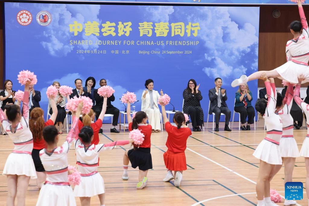 Peng Liyuan, wife of Chinese President Xi Jinping, watches calisthenics performed by the Chinese and the U.S. student cheerleaders, together with foreign and Chinese guests at Beijing No. 8 High School, in Beijing, capital of China, Sept. 24, 2024. Peng attended a China-U.S. youth cultural and sports exchange activity at Beijing No. 8 High School on Tuesday afternoon. (Photo: Xinhua)