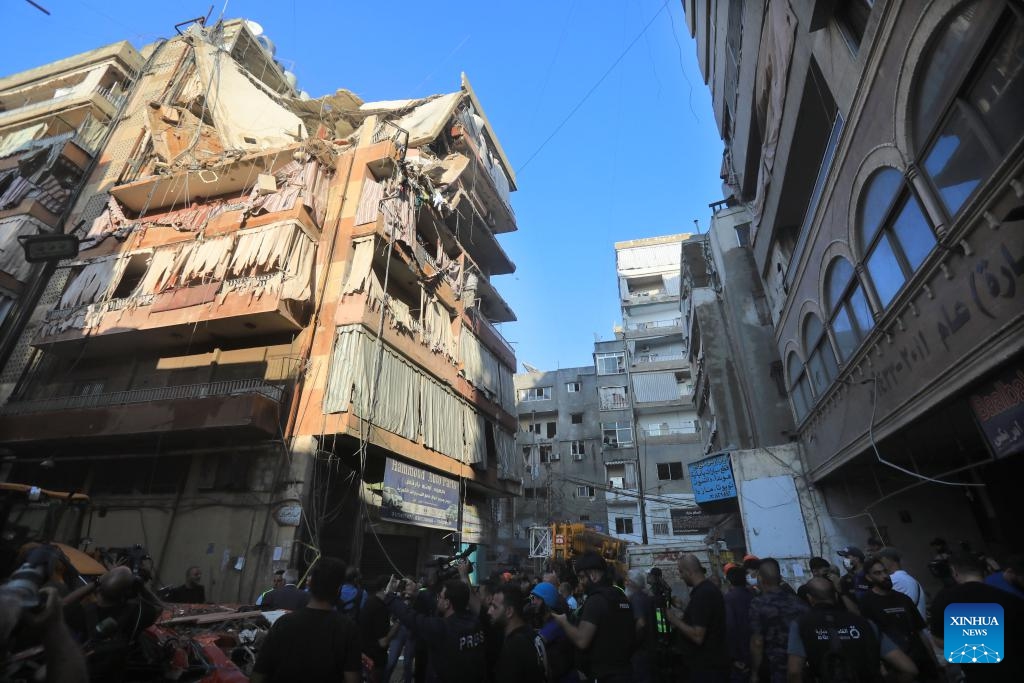 People gather at a building targeted by an Israeli warplane in Beirut, Lebanon, on Sept. 24, 2024. The Israeli military confirmed on Tuesday that it killed a senior Hezbollah commander in an airstrike on the southern suburbs of Beirut. In a statement, the military identified the commander as Ibrahim Muhammad Qubaisi, who was reportedly in charge of Hezbollah's missile and rocket operations. (Photo: Xinhua)