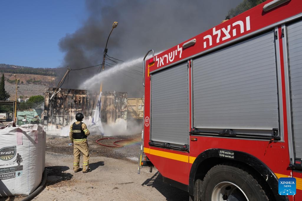 Firefighters work to extinguish a fire on a warehouse hit by a rocket from Lebanon, in Kiryat Shmona, northern Israel, on Sept. 24, 2024. The Israeli military reported that Hezbollah had resumed rocket fire on northern Israel, launching about 95 rockets since early Tuesday, with dozens landing in the cities of Kiryat Shmona, Nahariya, Afula, Nazareth, and Migdal Ha'emek. (Photo: Xinhua)