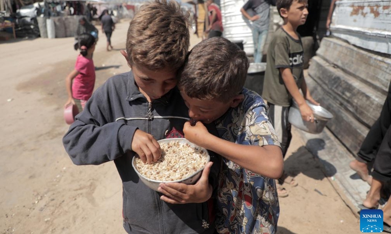 Palestinian children are seen after receiving food relief in the southern Gaza Strip city of Khan Younis, on Sept. 24, 2024. (Photo: Xinhua)