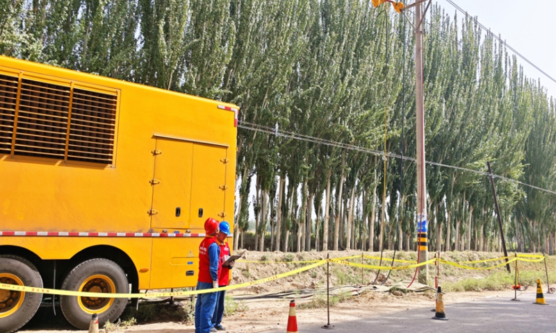 Staff at State Grid Aksu Power Supply Company conduct load testing and debugging on the 10 kV 1094 Ajiu Line. Photo: Wang Liangjun