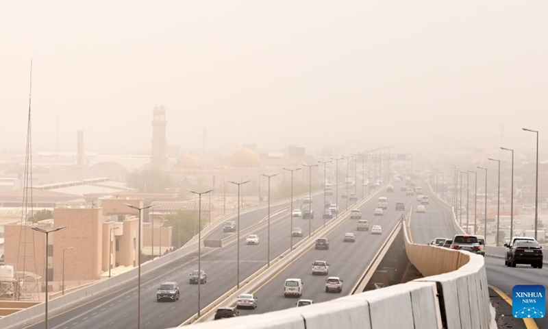 Cars drive on a road during a strong dust storm in Farwaniya Governorate, Kuwait on Sept. 26, 2024. (Photo: Xinhua)