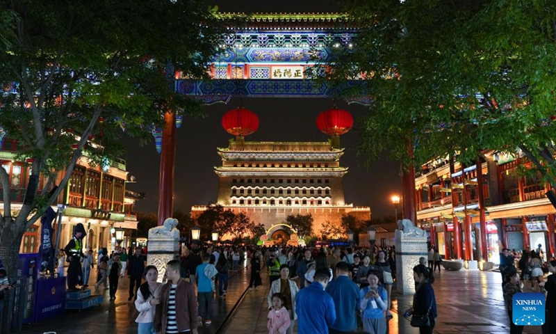 Tourists visit the Qianmen Street and the Zhengyang Gate arrow tower in Beijing, capital of China, Sept. 26, 2024. Beijing will activate over 2,800 nighttime illumination facilities from Sept. 29 to Oct. 7 to mark the 75th anniversary of the founding of the People's Republic of China. Upgraded illumination effects will be applied to landmarks along the Beijing Central Axis such as the Yongding Gate and the Bell and Drum Towers for the upcoming National Day holiday.  (Photo: Xinhua)