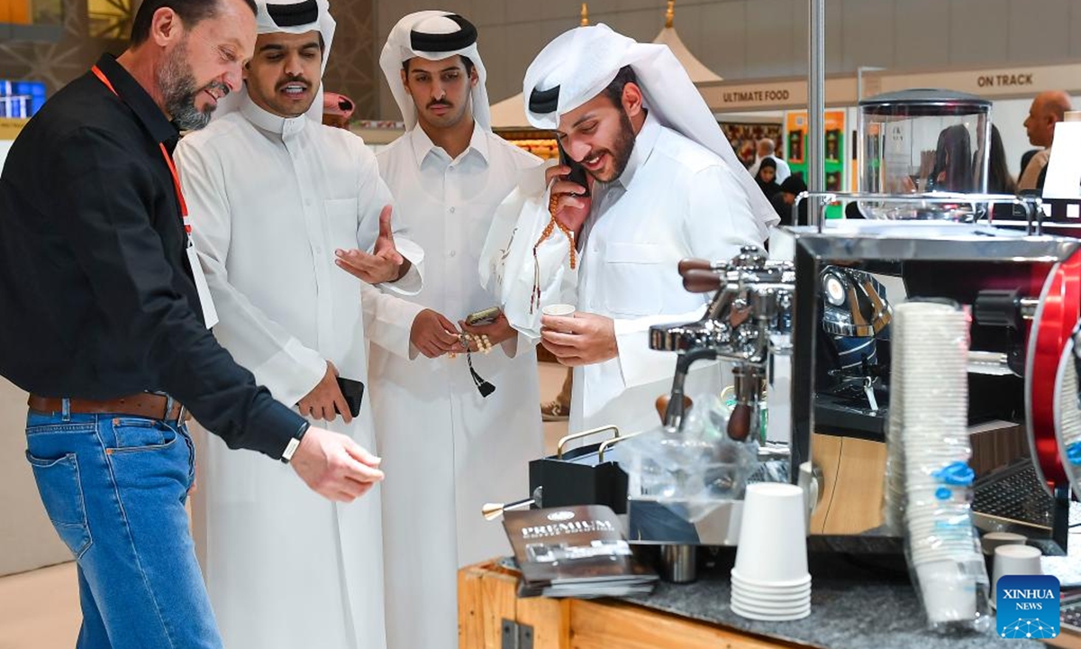 Visitors look at a coffee maker during the 2nd edition of Doha International Coffee Exhibition 2024 in Doha, Qatar, Sept. 27, 2024. The event is held here from Sept. 26 to 28. (Photo: Xinhua)