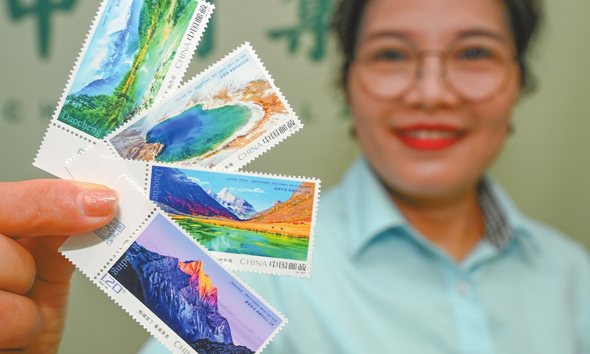 A China Post employee shows stamps featuring 