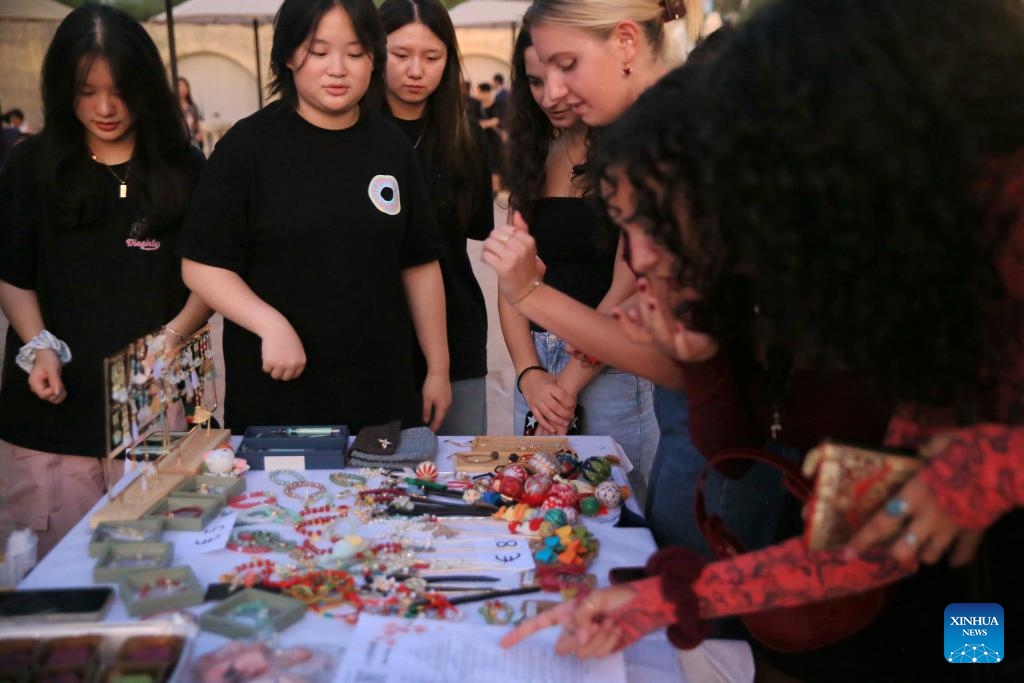 People attend the Chinese culture night event in Pembroke, Malta, Sept. 27, 2024. A Chinese culture night event was held on Friday evening in Pembroke, eastern Malta, drawing significant participation from the local community. The event showcased various aspects of Chinese culture, including traditional Chinese Medicine (TCM), Chinese calligraphy and painting, traditional music, and cuisine, alongside displays of exquisite Chinese handicrafts. (Photo: Xinhua)