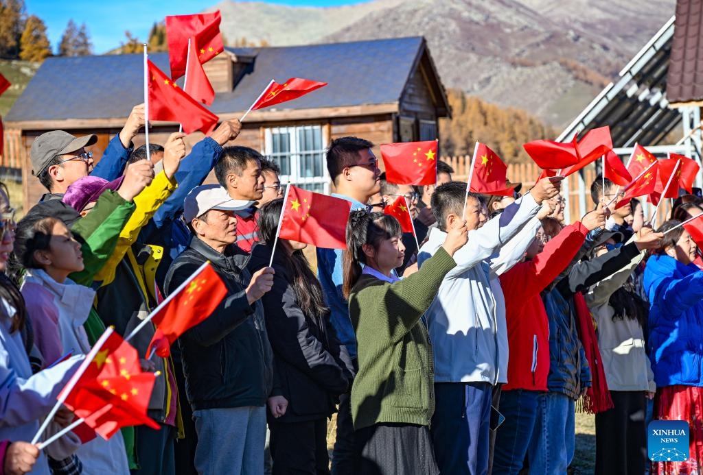 Tourists attend a flag-raising ceremony held to mark the 75th anniversary of the founding of the People's Republic of China at a border police station in Altay, northwest China's Xinjiang Uygur Autonomous Region on Oct. 1, 2024. (Photo: Xinhua)