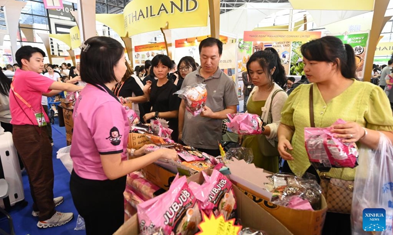 Visitors buy products from Thailand during the 21st China-ASEAN Expo at Nanning International Convention and Exhibition Center in Nanning, south China's Guangxi Zhuang Autonomous Region, Sept. 28, 2024. Products from the Association of Southeast Asian Nations (ASEAN) countries, such as durians, cookies and rosewood, as well as those from other countries including Russian sausages and Peruvian alpaca-fur stuffed toys have enjoyed popularity at the 21st China-ASEAN Expo in Nanning. (Photo: Xinhua)