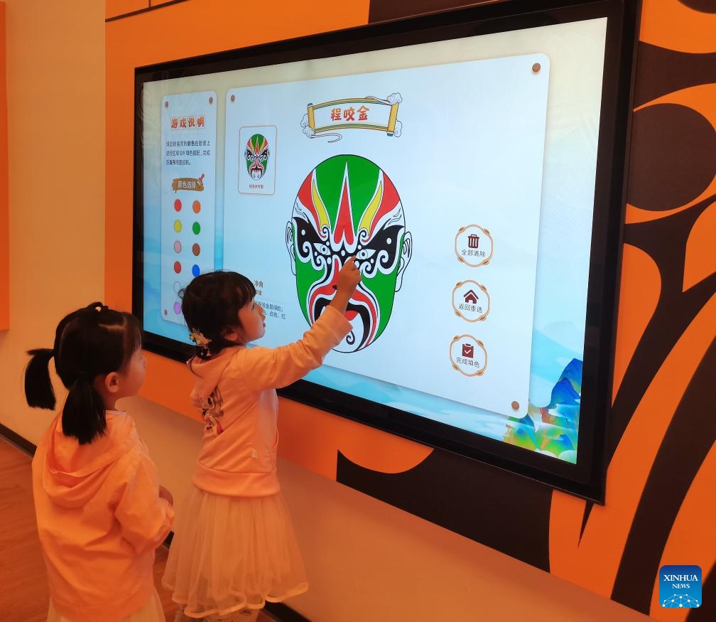 A child clicks on an electronic screen to color an opera mask at the interactive experience space of a museum dedicated to local operas in Kunshan City, east China's Jiangsu Province, Sept. 8, 2024. (Photo: Xinhua)