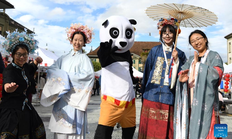 Visitors in folk costumes pose for a photo during a cultural event themed Meet China: Celebrating the 75th Anniversary of the Founding of the People's Republic of China at Waisenhaus Square in Bern, the capital of Switzerland, Sept. 27, 2024. (Photo: Xinhua)