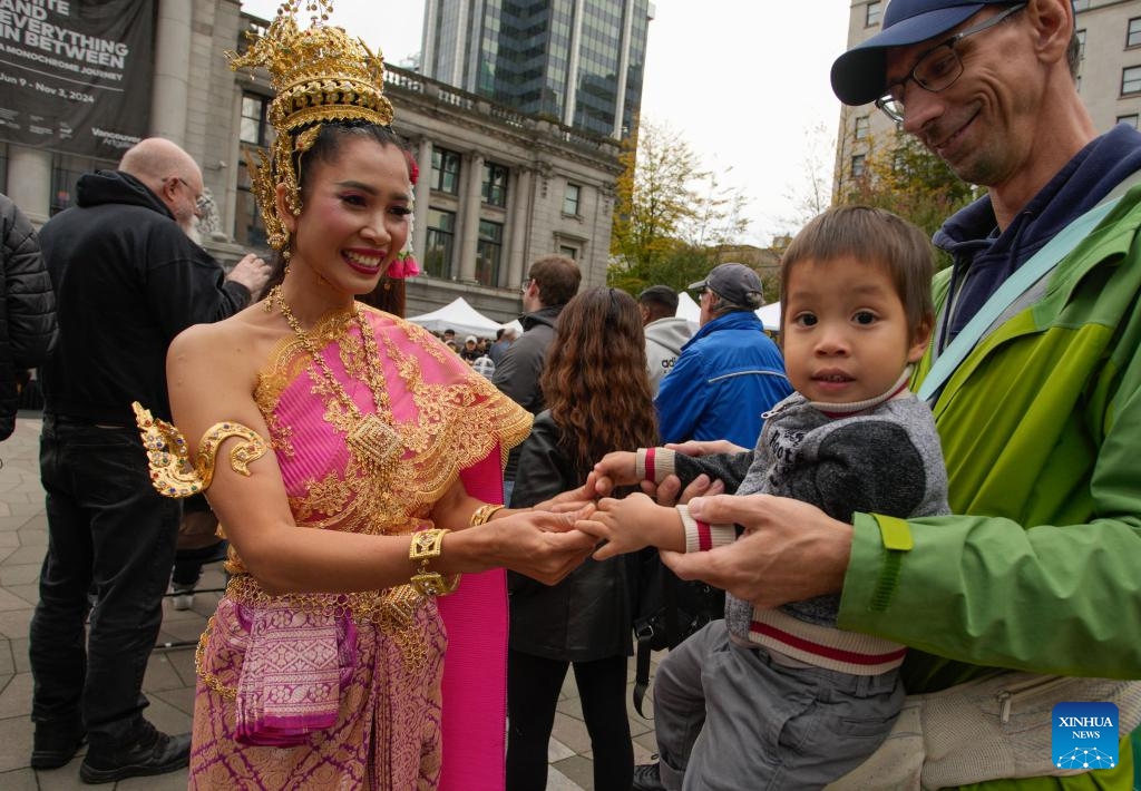 A Thai dancer interacts with a child during the 2024 Thai Festival at the Vancouver Art Gallery plaza in Vancouver, British Columbia, Canada, Sept. 28, 2024. (Photo: Xinhua)