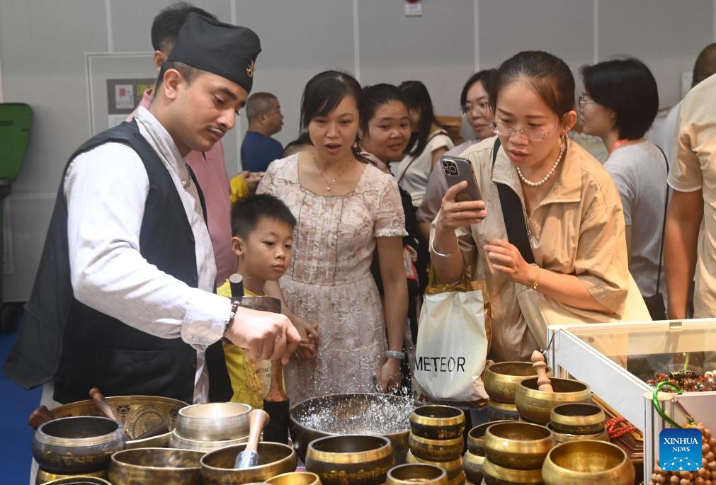 A staff member (1st L) introduces products from Nepal during the 21st China-ASEAN Expo at Nanning International Convention and Exhibition Center in Nanning, south China's Guangxi Zhuang Autonomous Region, Sept. 28, 2024. Products from the Association of Southeast Asian Nations (ASEAN) countries, such as durians, cookies and rosewood, as well as those from other countries including Russian sausages and Peruvian alpaca-fur stuffed toys have enjoyed popularity at the 21st China-ASEAN Expo in Nanning. (Photo: Xinhua)