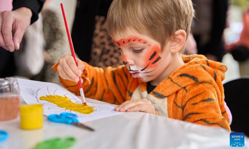 A child with tiger makeup draws a picture during the Tiger Day event in Vladivostok, Russia, Sept. 29, 2024. Since the year 2000, the last Sunday of September has been the Tiger Day in Russia. On Sunday, the city of Vladivostok hosted a variety of colorful events to promote awareness of protecting tigers and other wild animals. Photo: Xinhua