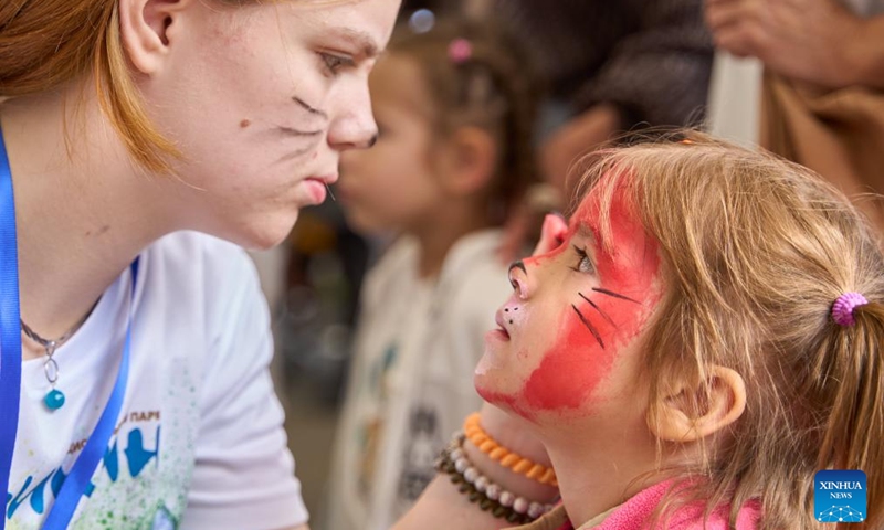 A volunteer paints tiger makeup on a child's face during the Tiger Day event in Vladivostok, Russia, Sept. 29, 2024. Since the year 2000, the last Sunday of September has been the Tiger Day in Russia. On Sunday, the city of Vladivostok hosted a variety of colorful events to promote awareness of protecting tigers and other wild animals. Photo: Xinhua