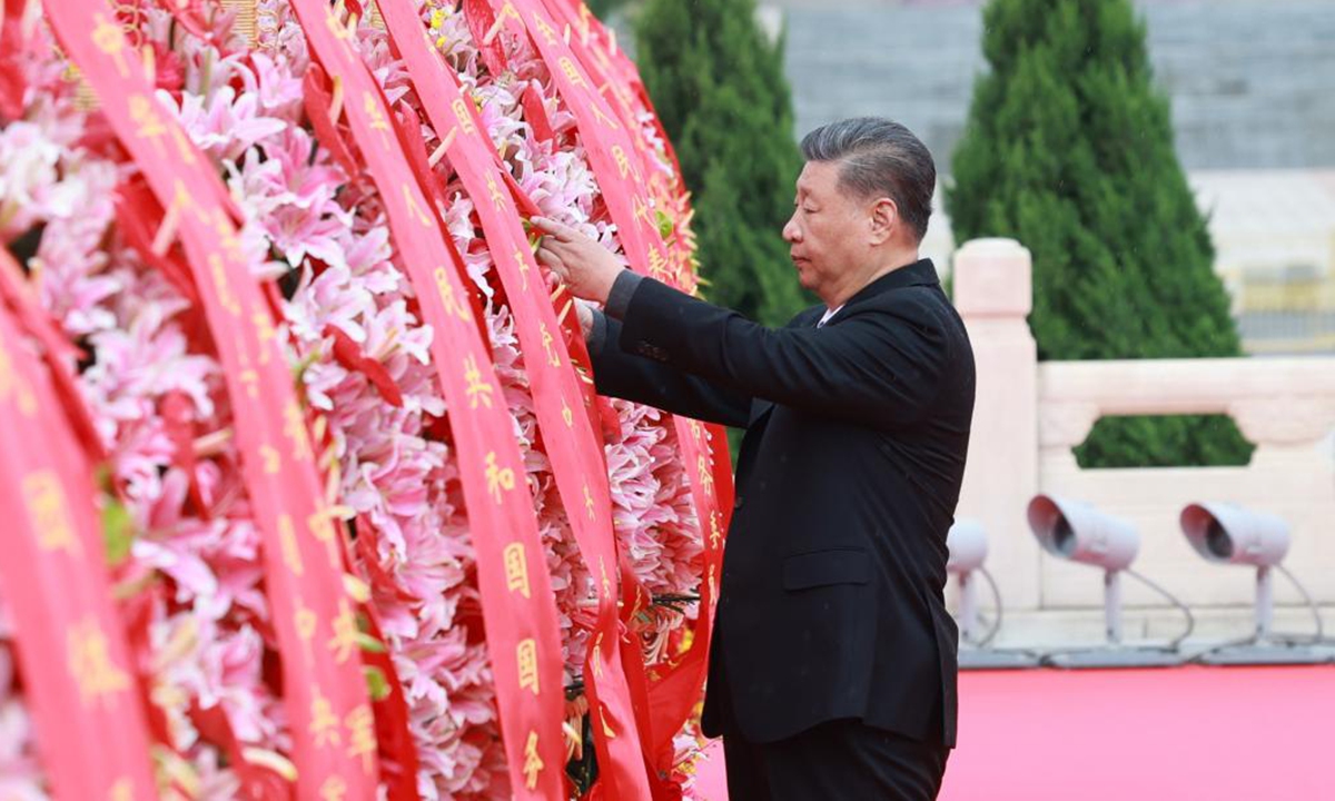 Xi Jinping straightens the ribbon on a flower basket during a ceremony to present flower baskets to fallen heroes at Tian'anmen Square in Beijing, capital of China, Sept. 30, 2024. (Photo: Xinhua)