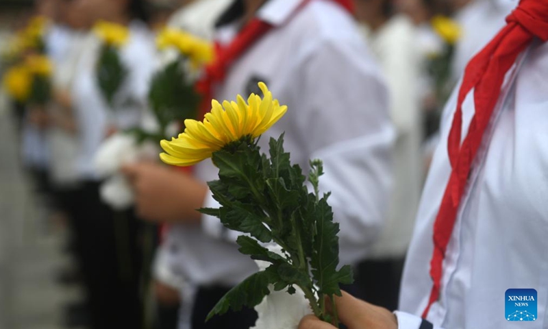 Students holding flowers attend a mourning ritual at a martyrs' cemetery in Nanning, south China's Guangxi Zhuang Autonomous Region, Sept. 30, 2024. (Photo: Xinhua)