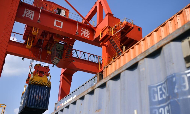 A container is lifted at Zhoukou Central Port in Zhoukou, central China's Henan Province, June 28, 2022. Strategically positioned in central part of the country, Henan has been serving as a national hub of transporation for ages. The past decades saw the province building a modern transportation network consisting air flights, railways, highways, water channels and all sorts of ports. It is now rapidly extending its role to areas of cross-border logistics, investment, and trade to facilitate the dual circulation of domestic and international markets. Photo: Xinhua