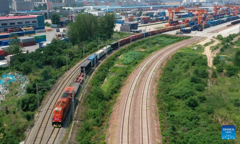 An aerial drone photo shows a China-Europe freight train pulling out of Putian Station in Zhengzhou, central China's Henan Province, July 18, 2023. Strategically positioned in central part of the country, Henan has been serving as a national hub of transporation for ages. The past decades saw the province building a modern transportation network consisting air flights, railways, highways, water channels and all sorts of ports. It is now rapidly extending its role to areas of cross-border logistics, investment, and trade to facilitate the dual circulation of domestic and international markets. Photo: Xinhua