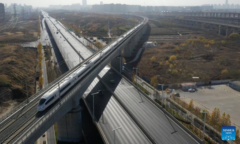 An aerial drone photo shows a bullet train running on a bridge in Zhengzhou, central China's Henan Province, Dec. 8, 2023. Strategically positioned in central part of the country, Henan has been serving as a national hub of transporation for ages. The past decades saw the province building a modern transportation network consisting air flights, railways, highways, water channels and all sorts of ports. It is now rapidly extending its role to areas of cross-border logistics, investment, and trade to facilitate the dual circulation of domestic and international markets. Photo: Xinhua