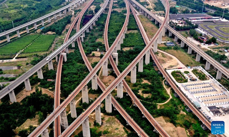 An aerial drone photo shows a bullet train running on a bridge in Zhengzhou, central China's Henan Province, May 30, 2024. Strategically positioned in central part of the country, Henan has been serving as a national hub of transporation for ages. The past decades saw the province building a modern transportation network consisting air flights, railways, highways, water channels and all sorts of ports. It is now rapidly extending its role to areas of cross-border logistics, investment, and trade to facilitate the dual circulation of domestic and international markets. Photo: Xinhua