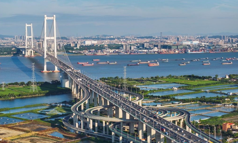 An aerial drone photo taken on Oct. 2, 2024 shows a view of the Nansha Bridge, which links Guangzhou City and Dongguan City, and ships along the Shiziyang channel in the Pearl River Estuary area, in south China's Guangdong Province. (Xinhua/Liu Dawei)