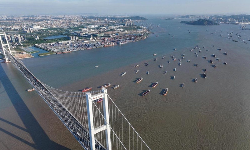 An aerial drone photo taken on Oct. 2, 2024 shows a view of the Nansha Bridge, which links Guangzhou City and Dongguan City, and ships along the Shiziyang channel in the Pearl River Estuary area, in south China's Guangdong Province. (Xinhua/Liu Dawei)