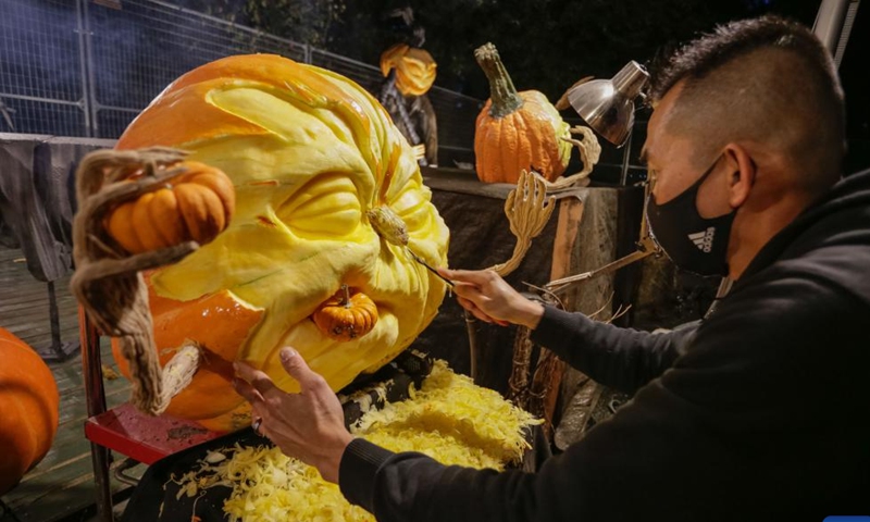 An artist carves a pumpkin at the 2024 Pumpkins After Dark event in Burnaby, British Columbia, Canada, Oct. 2, 2024. Featuring more than 10,000 hand-carved pumpkins and brand-new displays, the annual outdoor walk-through event kicked off on Wednesday and will run until Oct. 31 this year. (Photo by Liang Sen/Xinhua)