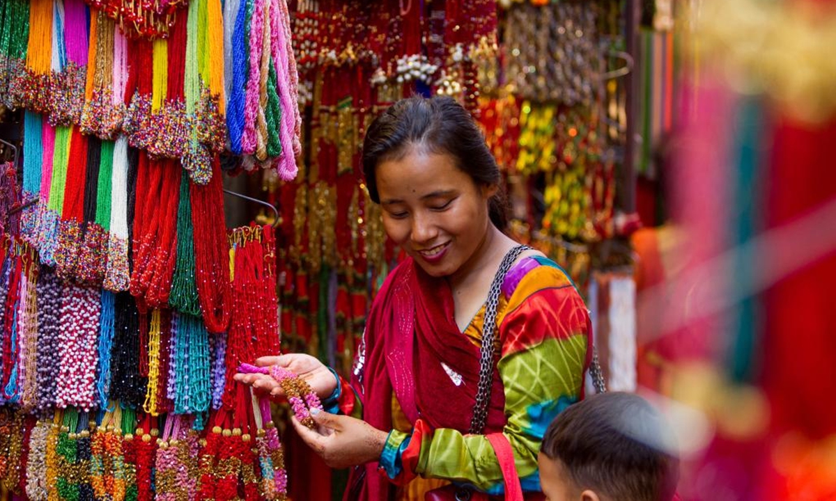 A woman is seen at a bead shop during the Hindu holy month of Shrawan in Kathmandu, Nepal, July 28, 2023. (Photo by Sulav Shrestha/Xinhua)